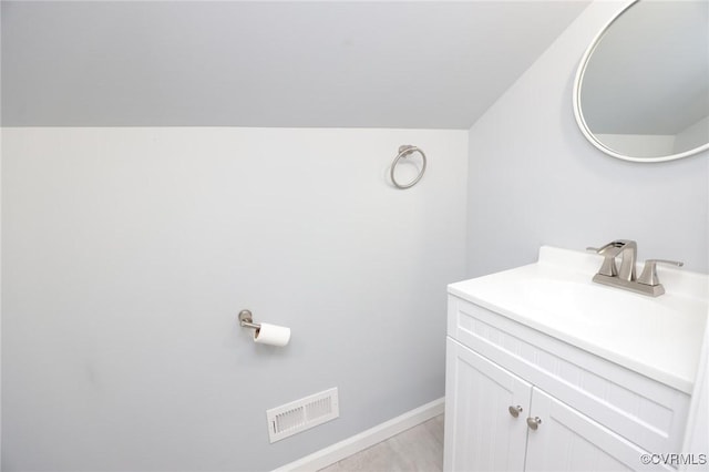 bathroom featuring visible vents, baseboards, and vanity