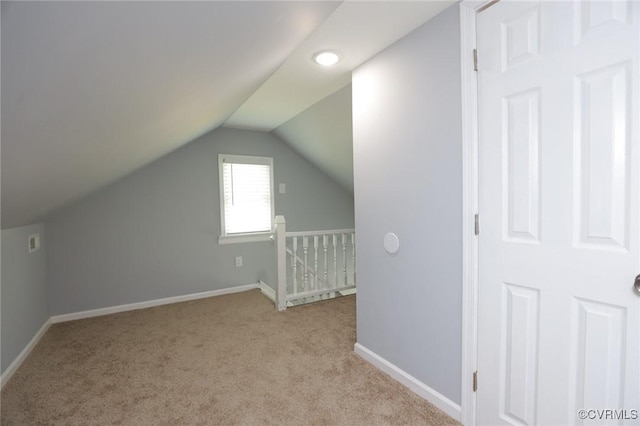 bonus room featuring baseboards, vaulted ceiling, and light carpet