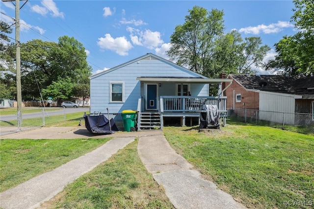 bungalow-style home featuring fence, covered porch, and a front lawn