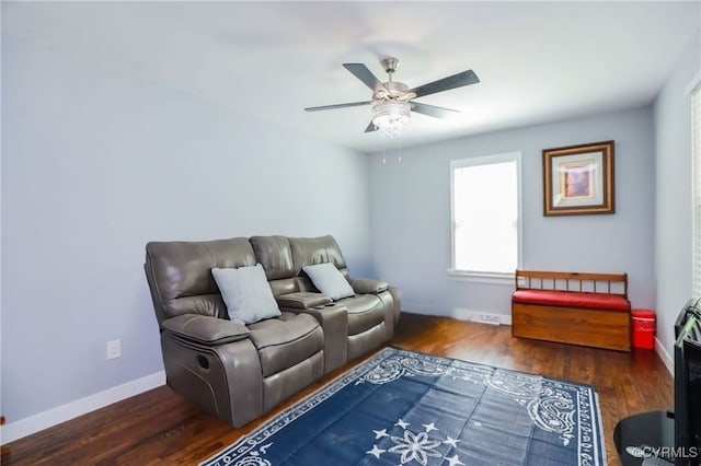 living room featuring a ceiling fan, baseboards, and wood finished floors