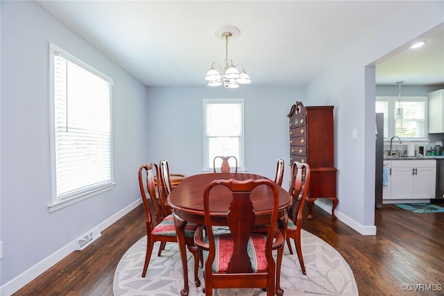 dining space featuring visible vents, dark wood finished floors, baseboards, and an inviting chandelier