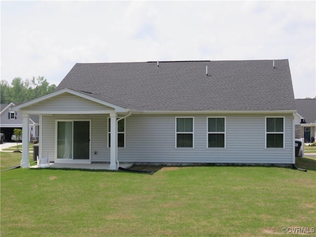 back of house featuring a lawn and a shingled roof