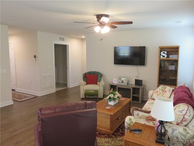 living area with baseboards, ceiling fan, visible vents, and wood finished floors