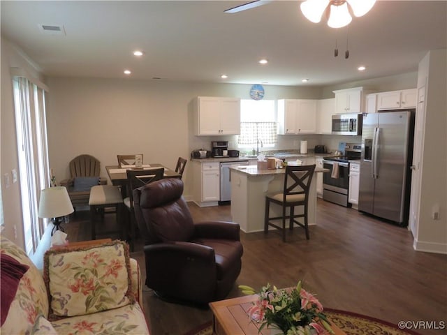 living area with recessed lighting, a ceiling fan, visible vents, and dark wood-type flooring