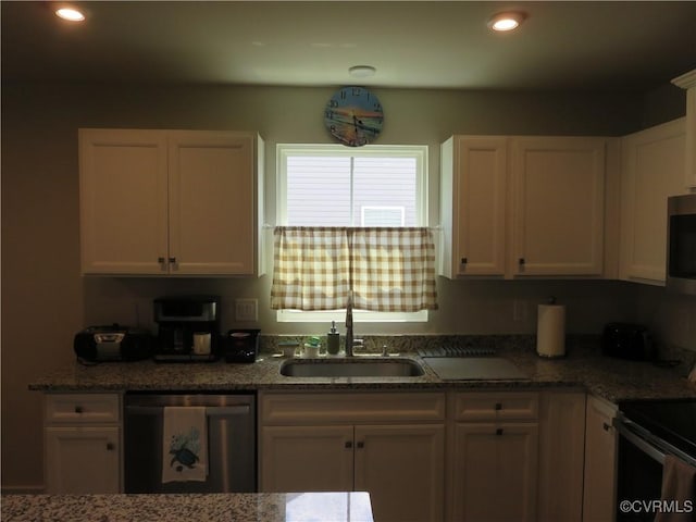 kitchen featuring a sink, stone countertops, stainless steel appliances, and white cabinetry