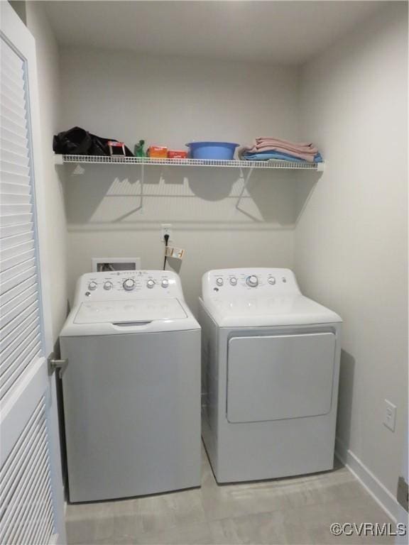 laundry area featuring laundry area, washing machine and dryer, and baseboards