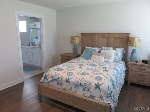 bedroom featuring baseboards, a sink, ensuite bath, and dark wood-style floors