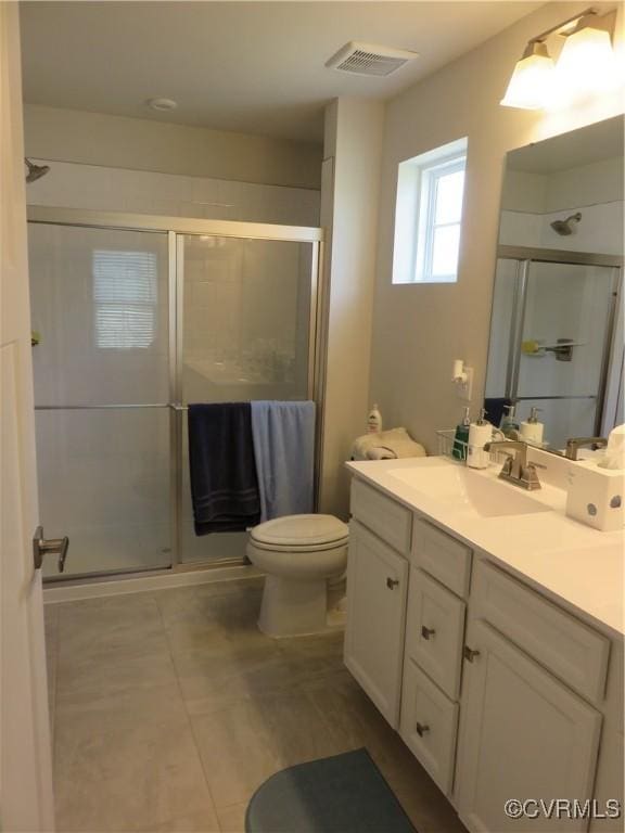 bathroom featuring visible vents, tile patterned flooring, vanity, toilet, and a stall shower