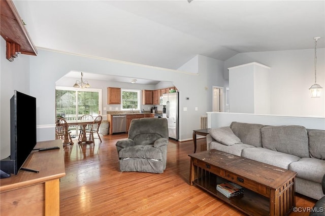 608 Southampton Dr, Ruther Glen, VA 22546 - living room with lofted ceiling, light wood-style flooring, a chandelier, and arched walkways