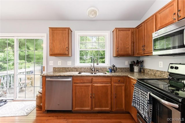 608 Southampton Dr, Ruther Glen, VA 22546 - kitchen with stainless steel appliances, a sink, dark wood-style floors, brown cabinetry, and light stone counters