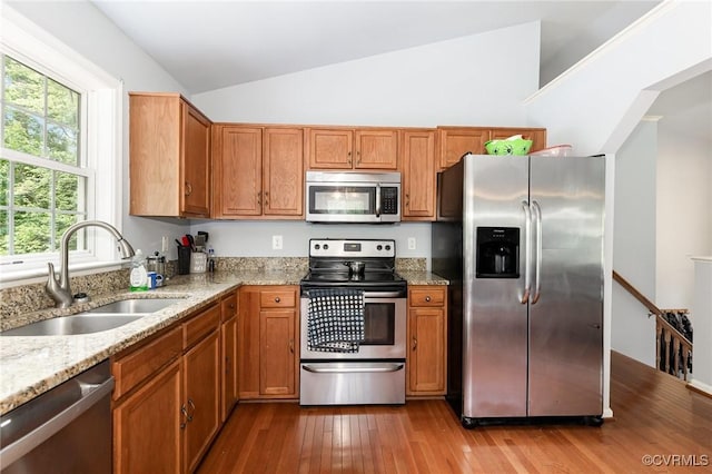 608 Southampton Dr, Ruther Glen, VA 22546 - kitchen featuring appliances with stainless steel finishes, a sink, vaulted ceiling, wood-type flooring, and light stone countertops