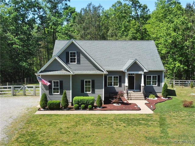 craftsman-style home with a shingled roof, a front lawn, and fence