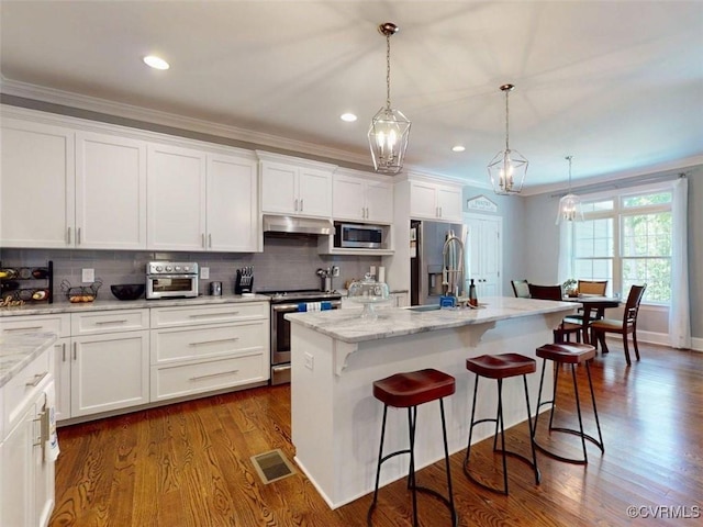 kitchen featuring visible vents, appliances with stainless steel finishes, a sink, white cabinets, and under cabinet range hood