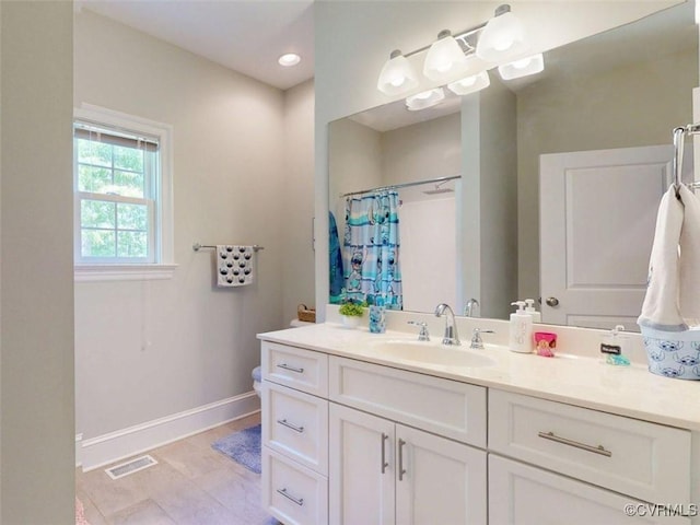 full bath with visible vents, baseboards, curtained shower, and vanity