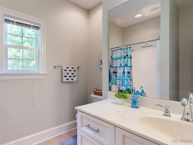 bathroom with vanity, toilet, a shower with shower curtain, baseboards, and wood finished floors