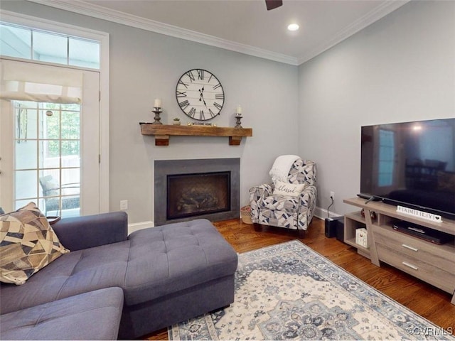 living room with ornamental molding, wood finished floors, a fireplace, baseboards, and recessed lighting