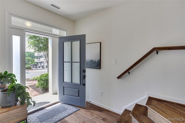 entryway featuring visible vents, baseboards, stairs, and wood finished floors