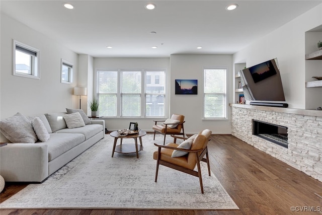 living room with recessed lighting, wood finished floors, and a fireplace