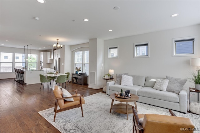 living area featuring dark wood-style flooring, recessed lighting, and a chandelier