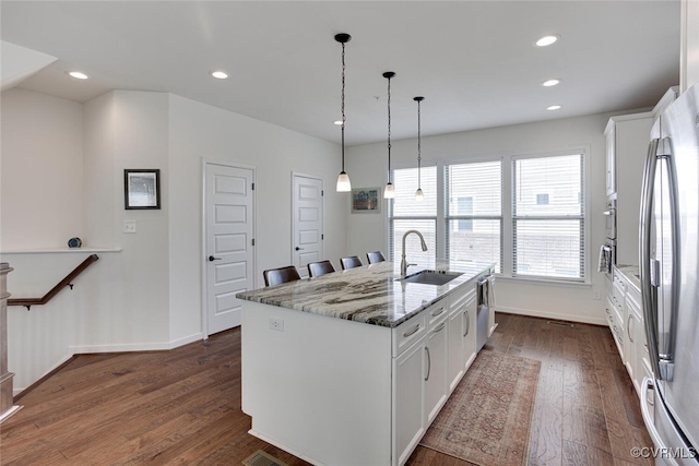kitchen featuring dark wood-style flooring, appliances with stainless steel finishes, white cabinetry, and a sink