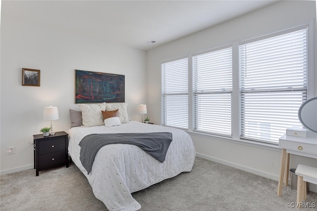 carpeted bedroom with baseboards, multiple windows, and visible vents