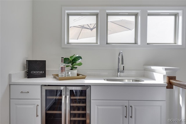 bar featuring wine cooler, indoor bar, a sink, and a healthy amount of sunlight