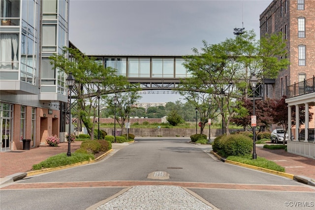 view of street with sidewalks, traffic signs, curbs, and street lights