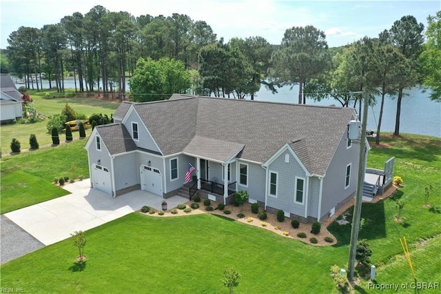 ranch-style house with concrete driveway, a water view, a shingled roof, and a front yard