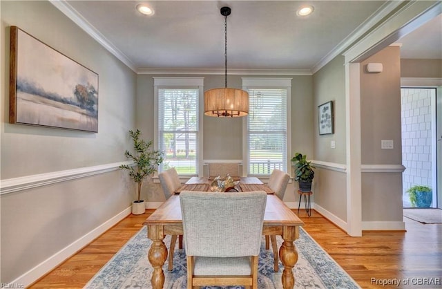 dining area with light wood-style floors, baseboards, crown molding, and recessed lighting
