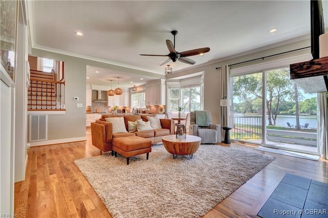 living area with ornamental molding, recessed lighting, ceiling fan, and visible vents