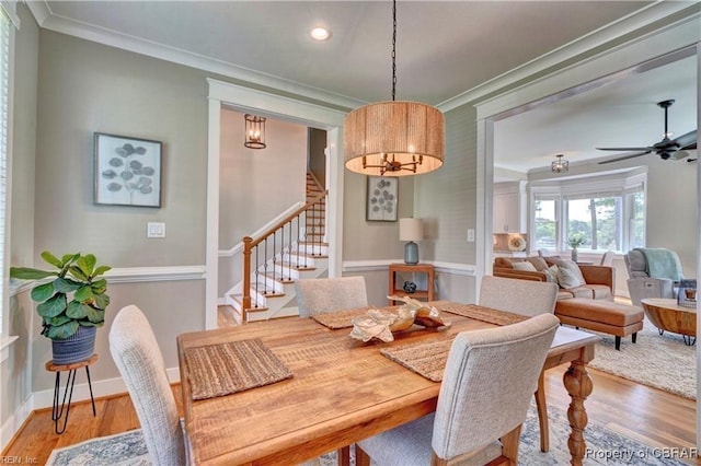 dining space featuring stairway, ornamental molding, recessed lighting, and wood finished floors