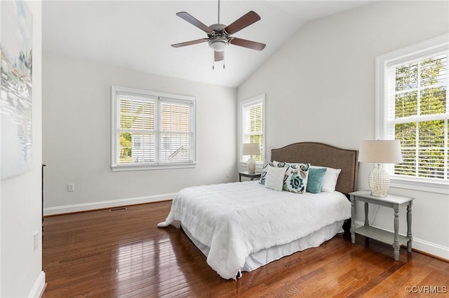 bedroom featuring baseboards, multiple windows, wood finished floors, and lofted ceiling
