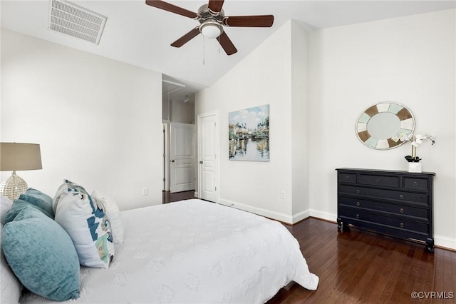 bedroom featuring attic access, hardwood / wood-style floors, baseboards, lofted ceiling, and visible vents
