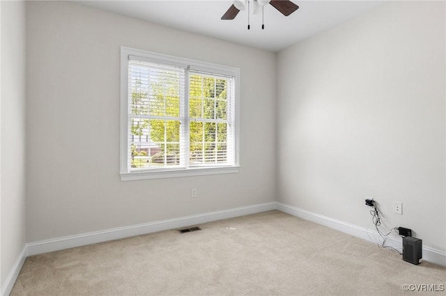 carpeted empty room featuring baseboards, a ceiling fan, and visible vents