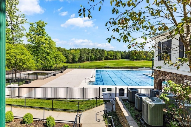 pool featuring central air condition unit, fence, and a patio area