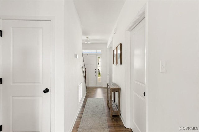 corridor featuring visible vents, dark wood finished floors, and baseboards