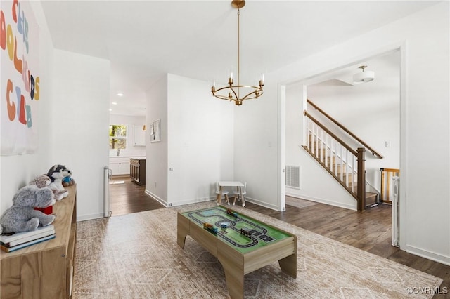 10001 Craftsbury Dr, Midlothian, VA 22312 - living room with a chandelier, wood finished floors, stairway, and baseboards
