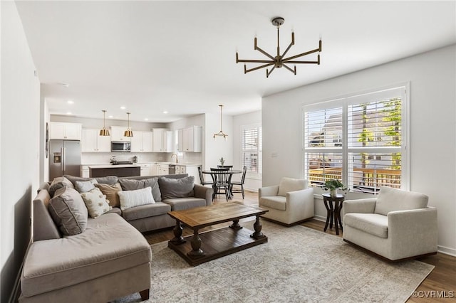 living room featuring recessed lighting, baseboards, a chandelier, and wood finished floors