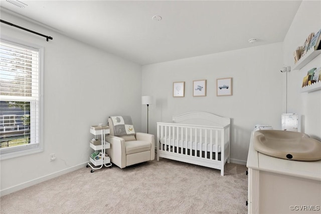 bedroom featuring carpet floors, a crib, and baseboards