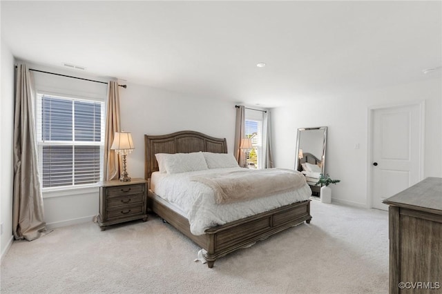 bedroom with visible vents, baseboards, and light colored carpet