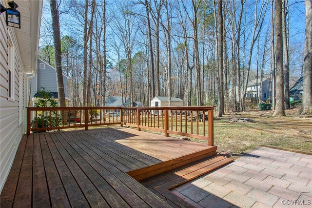 wooden deck featuring an outbuilding and a shed
