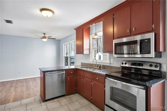 kitchen featuring a sink, stainless steel appliances, a ceiling fan, a peninsula, and visible vents