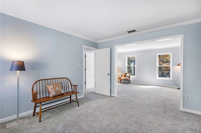 sitting room with crown molding, carpet flooring, baseboards, and visible vents