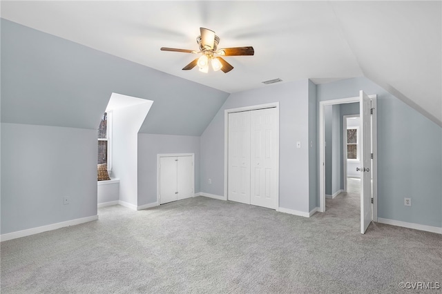 additional living space featuring a ceiling fan, visible vents, baseboards, lofted ceiling, and carpet