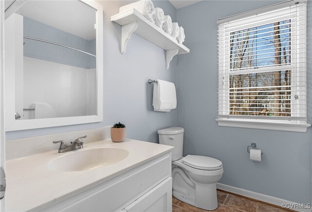 full bath with toilet, baseboards, walk in shower, and vanity
