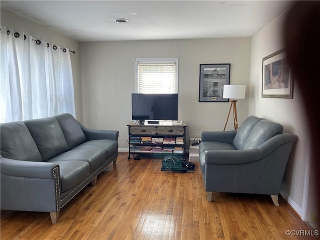 living area with hardwood / wood-style flooring and baseboards
