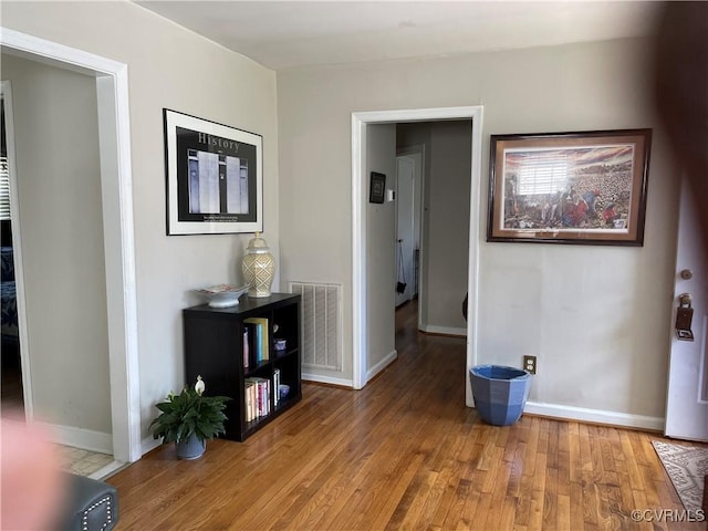 hallway with wood finished floors and baseboards