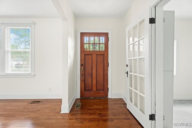 entrance foyer with baseboards, visible vents, and wood finished floors