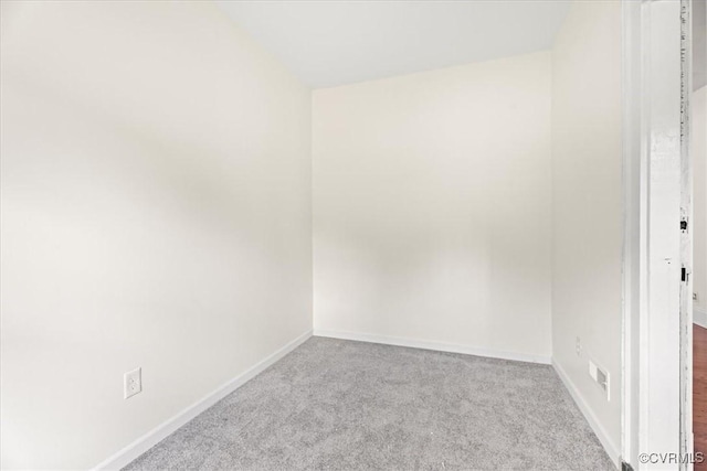 carpeted empty room featuring baseboards