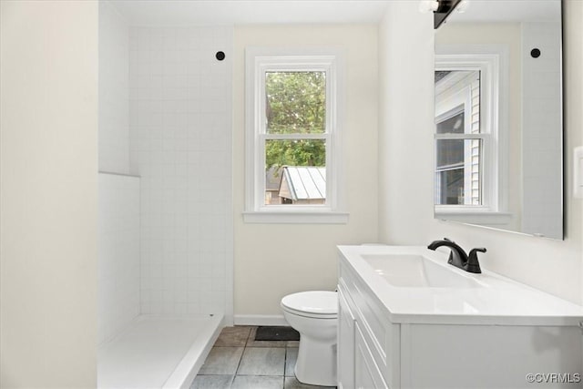 full bathroom featuring vanity, toilet, tile patterned floors, baseboards, and tiled shower